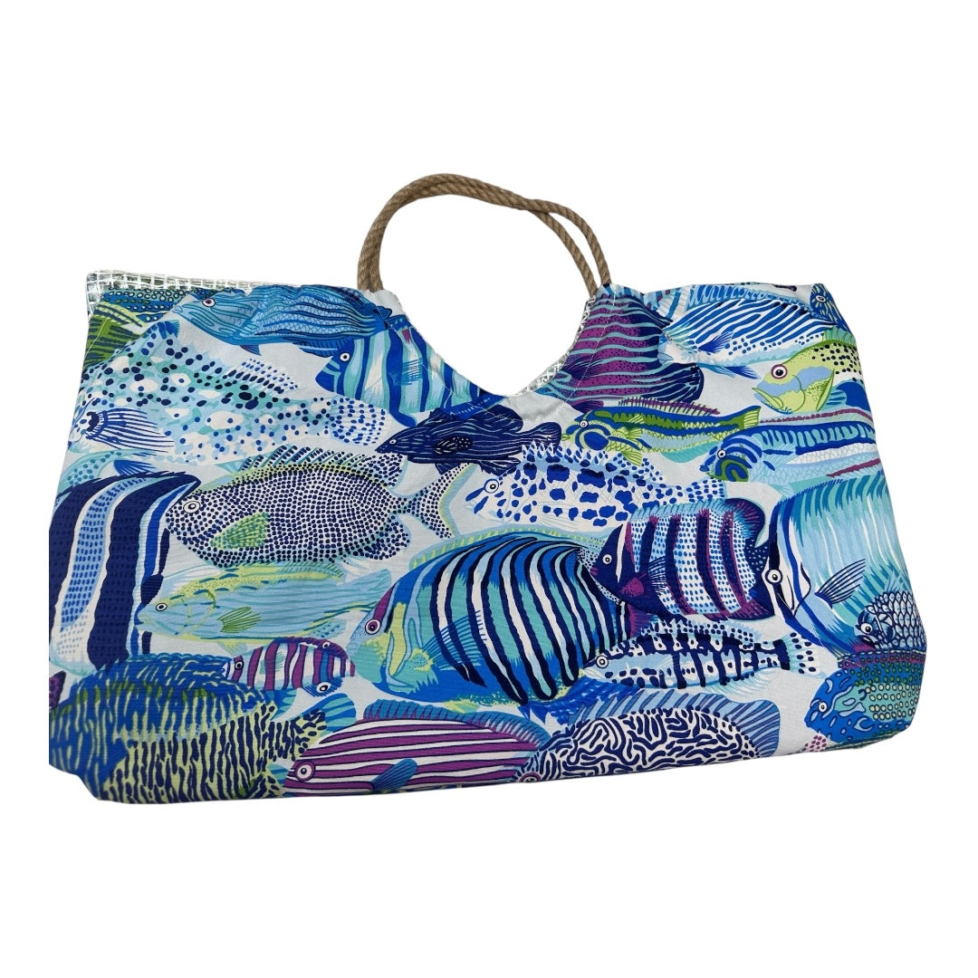 Large canvas beach tote bag featuring a vibrant all-over tropical fish print in shades of blue, purple, and green. The bag has a wide open-top design, thick nautical rope handles, and a silver water-resistant interior lining shown at the top edgE